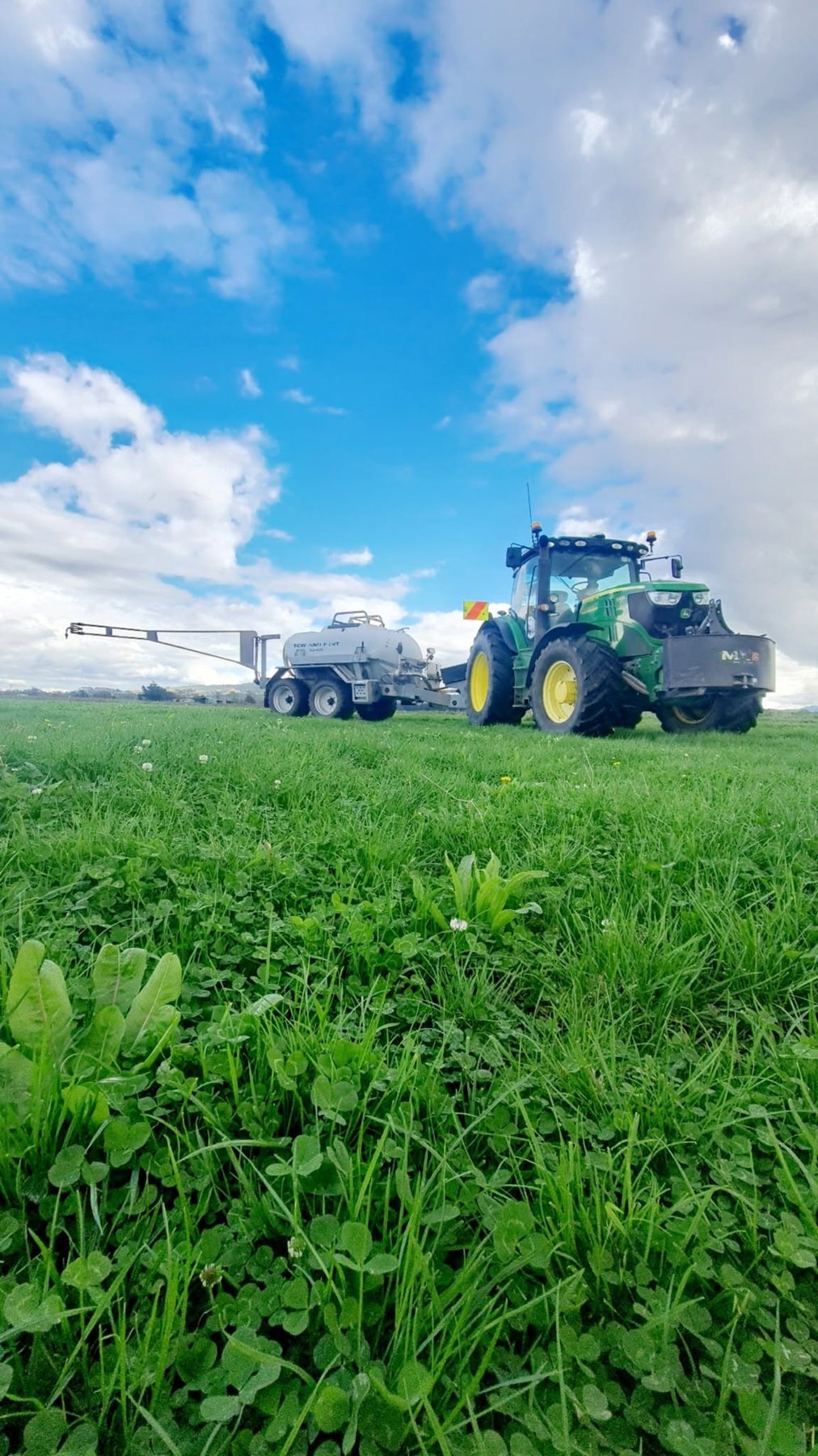 John Deere with spray tank on clover pasture